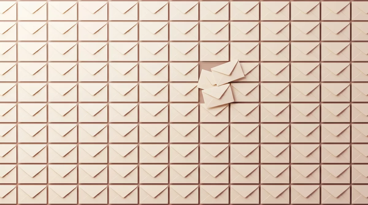 Overhead flat-lay of thousands of identical plain cream envelopes filling the frame in a grid, with 